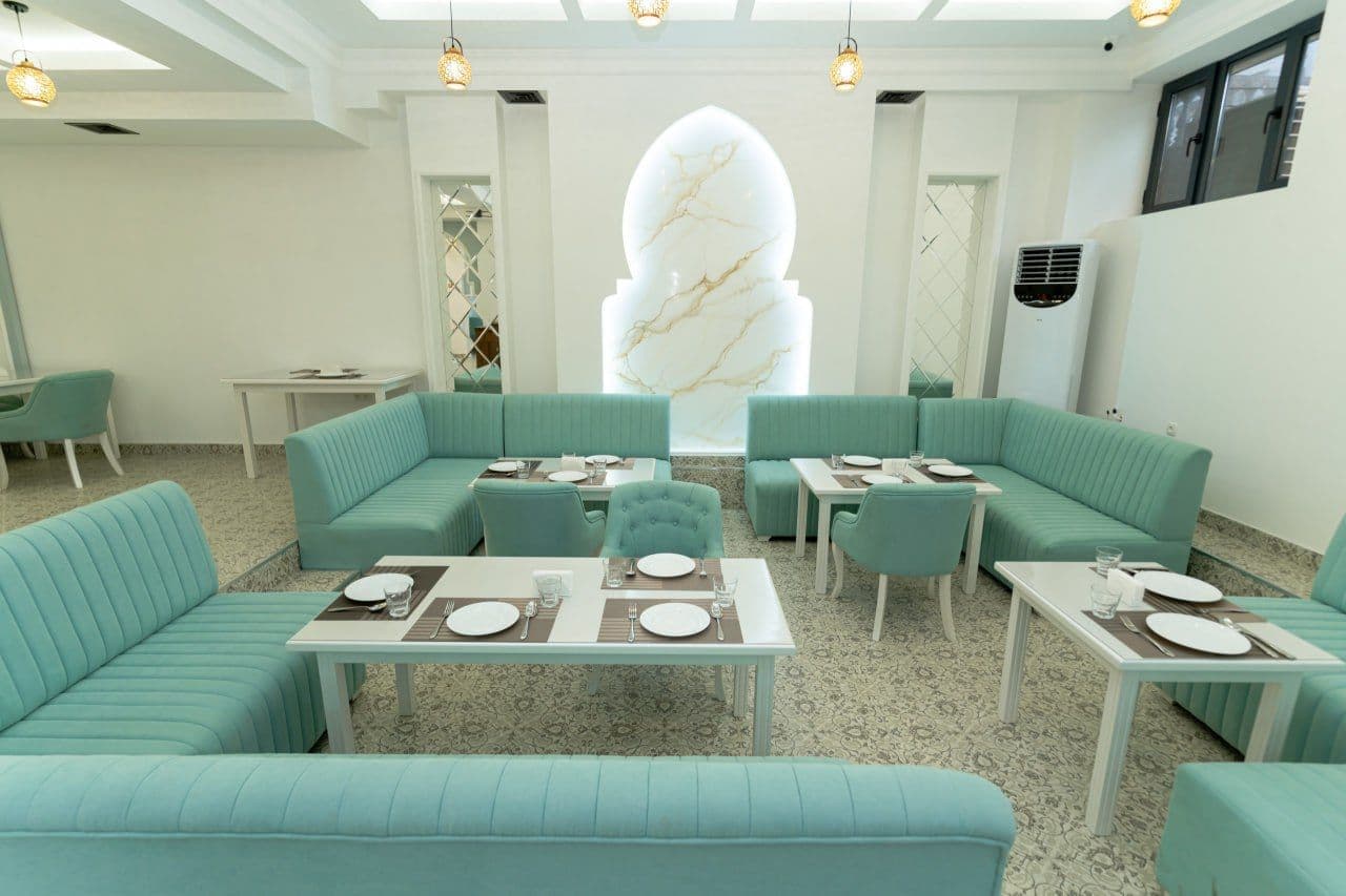 The turquoise breakfast room of The Heritage Tashkent, with arched wall panels